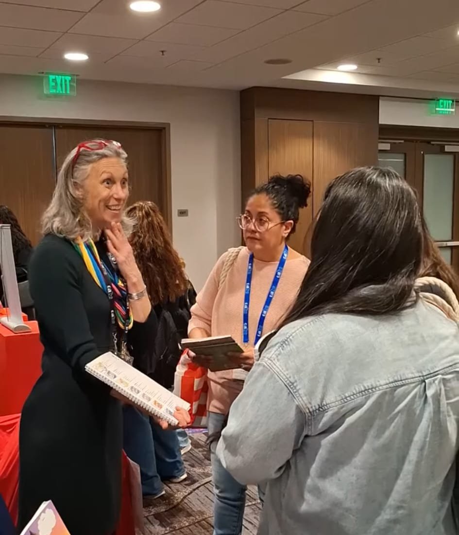 Elizabeth talking with educators about reading materials at a conference